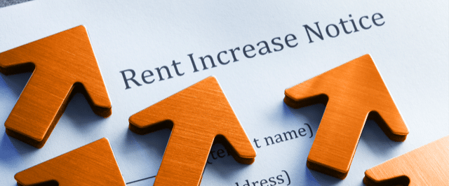 Close-up of a 'Rent Increase Notice' with wooden arrows pointing towards it, symbolizing the strategy of how to raise rent without losing tenants.