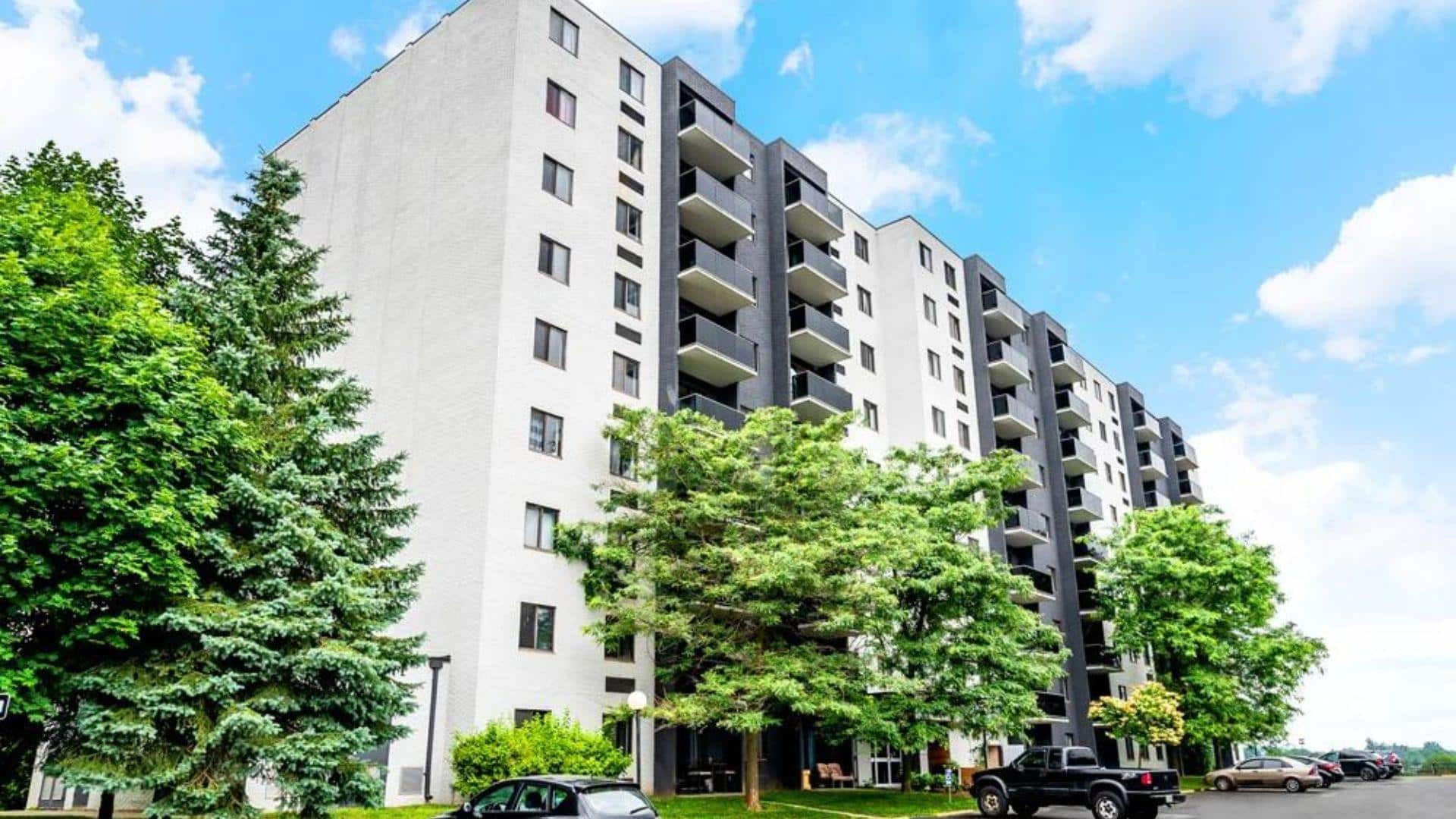 Modern mid-rise apartment building with balconies and well-maintained landscaping, illustrating opportunities to invest in apartment buildings.