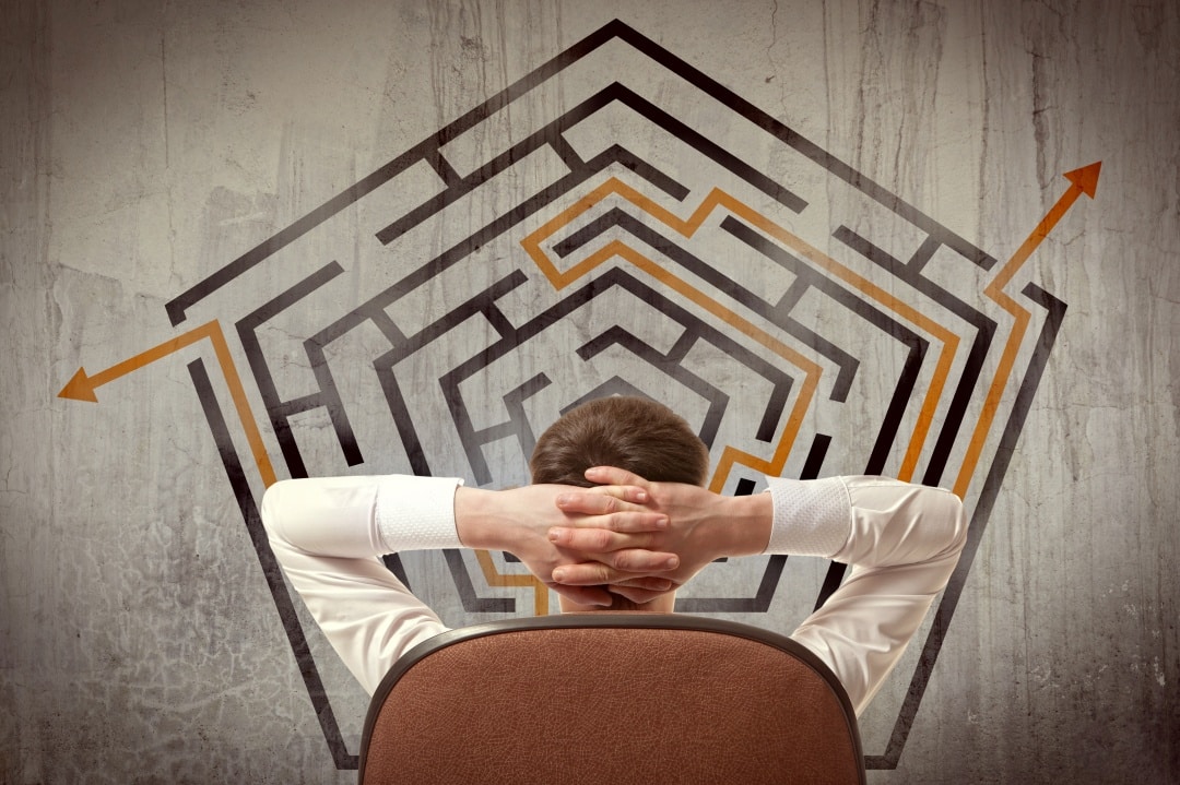 Man planning real estate investment exit strategy, facing a maze with paths leading to different outcomes, symbolizing decision-making